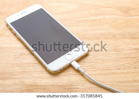 Smartphone charging with power bank on wood board
