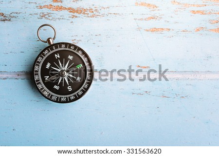 Black compass on wooden board