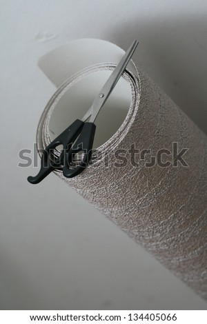 Roll of wallpaper and scissors.