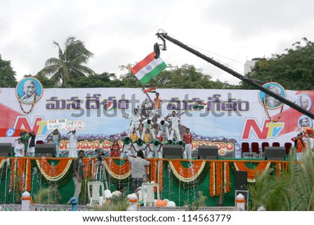 HYDERABAD,AP,INDIA-AUGUST 28:School Children assemble with  flag,  to render national anthem,to mark 100 th year of the song, in  event by NTV ar NTR ground on August 28,2012 in Hyderabad,India.