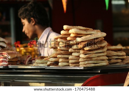 HYDERABAD,AP,INDIA-DECEMBER 22: Vendor sell bakery food in a crowded road on December 22,2013 in Hyderabad,Ap,India.Popular street food available in all places in india.
