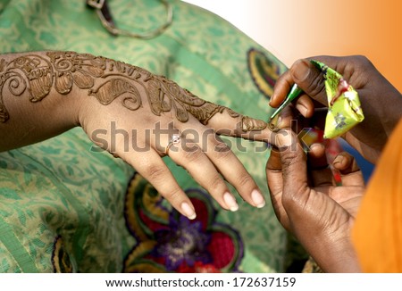 Applying henna - dye prepared from the plant henna tree for temporary tattooing.