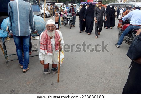 HYDERABAD,INDIA-JULY 21:Indian handicapped man seeking help in a busy road in Hyderabad,India on July 21,2014.