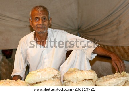 HYDERABAD,INDIA-FEBRUARY 14:Indian old man a street vendor sell street food in a busy road in Hyderabad,India on February 14,2012.