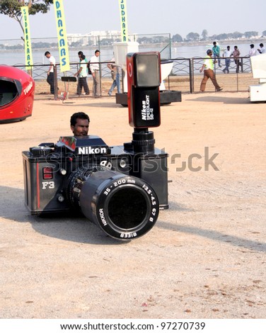 HYDERABAD,AP,INDIA-FEBRUARY 04:Driver demonstrates car shaped Digital camera in exhibition February 04,2012 in Hyderabad,AP,India. Guinness World Record Holder for Largest Tricycle exhibited Cars.