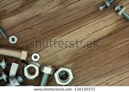 Shiny Nuts and Bolts on Weathered Wood Background