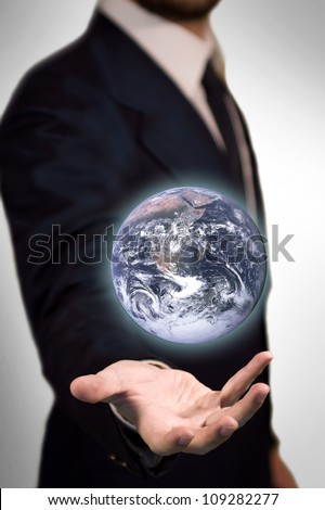 Earth Sphere (furnished by NASA) in the palm of a business man like a magic sphere