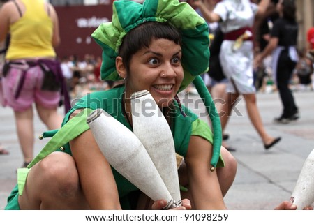 BOLOGNA, ITALY - JUN 18: a nice girl with two clubs in her hands masked as joker smiling to someone during the \'Partòt\' Street Parade 2011 in \'Piazza Maggiore\' Bologna, Italy on Jun 18, 2011.