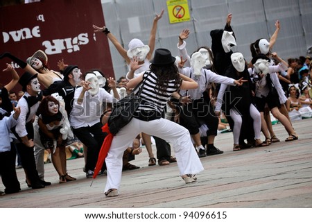 BOLOGNA, ITALY - JUN 18:a group of masked people performing a strange dance all together during the \'Partòt\' Street Parade 2011 in \'Piazza Maggiore\' Bologna, Italy on Jun 18, 2011.