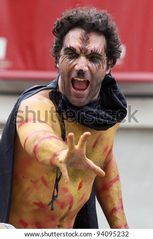 BOLOGNA, ITALY - JUN 18: Evil Masked man scaring people making strange faces during the \'Partòt\' Street Parade 2011 in \'Piazza Maggiore\' Bologna, Italy on Jun 18, 2011.
