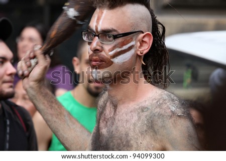 BOLOGNA, ITALY - JUN 18: A man masked as jurassic man with a club during the \'Partòt\' Street Parade 2011 in \'Piazza Maggiore\' Bologna, Italy on Jun 18, 2011.