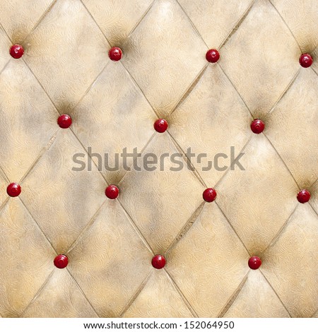 Sample of buttoned concrete wall simulating couch texture. Golden and red combination.