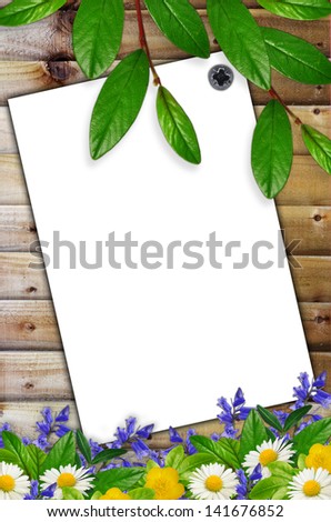 White sheet of paper and wild flowers on the wooden background