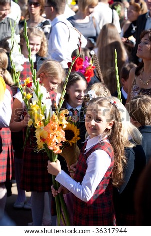 VILNIUS, LITHUANIA - SEPTEMBER 1: Schoolgirls hold flowers and are on the point to greet their teacher on September 1, 2009 in Vilnius, Lithuania.