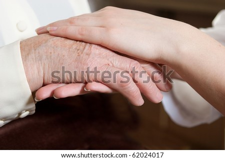 Helping hands: the nurse holds hands of the elderly female