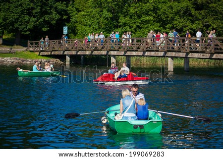 TRAKAI, LITHUANIA - JUNE 7: People boating in the lake Galve in front of Trakai Island Castle on June 7, 2014 in Trakai. Trakai Island Castle built in 14th century, now is a major tourist attraction.