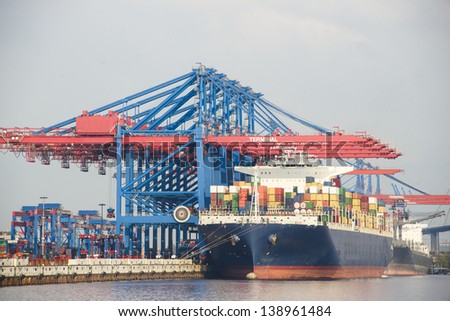 a big container ship in the port terminal is loaded