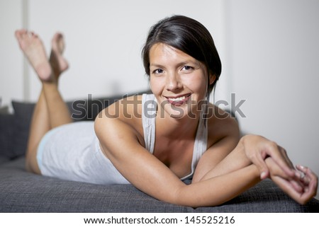 attractive woman lying on lounge sofa and smiling