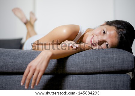woman lay down on sofa and smiles