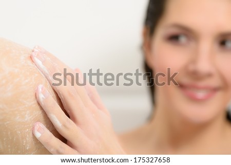 Young woman enjoying a relaxing bath soaping her skin to wash away the dirt from her days activities as she cares for her skin in a personal hygiene and beauty concept