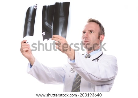 Male doctor, radiologist or orthopedic surgeon comparing two x-rays holding them up to the light, isolated on white