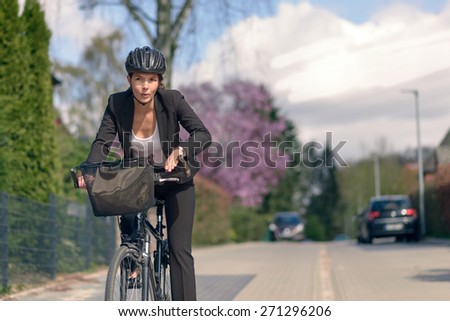 Young Active Businesswoman Commuting on a Bicycle with Protective Helmet Going to her Office