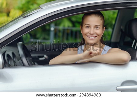 Pretty Young Woman Sitting Inside the Car, Smiling at the Camera While Leaning on the Open Window