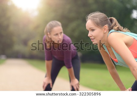 Two Young Women Resting After their Outdoor Physical Exercise at the Park.