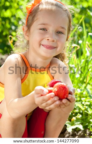 Smile little girl in summer day with strawberries