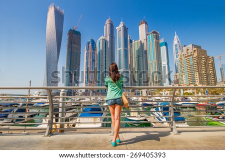 Young woman looking on skyscrapers in Dubai Marina