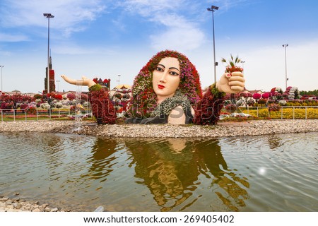 DUBAI, UAE - MARCH 28:  Women with flower in Dubai Miracle Garden in the UAE on March 28, 2015. It has over 45 million flowers.