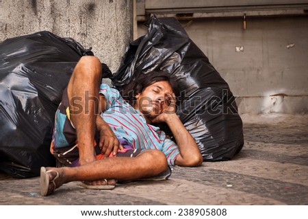 RIO DE JANEIRO, BRAZIL - DECEMBER 4, 2014: Homeless man sleeping on plastic bags. Even though economy of Brazil is growing rapidly, poverty remains a big issue there.