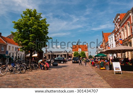 Heusden, Netherlands - July 6, 2013: Sunny summer day in the main square of a medieval Dutch town Heusden. Every weekend people are dining and hanging out here.