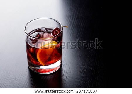 Old fashioned cocktail on the black wooden table