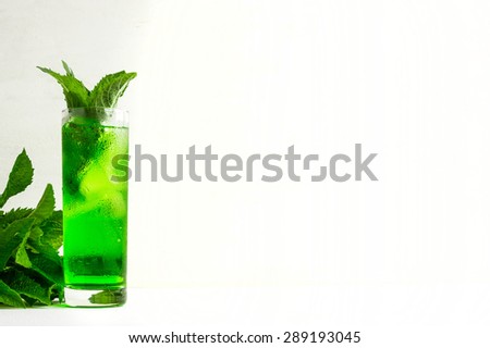 Green cocktail with mint on the white wooden background