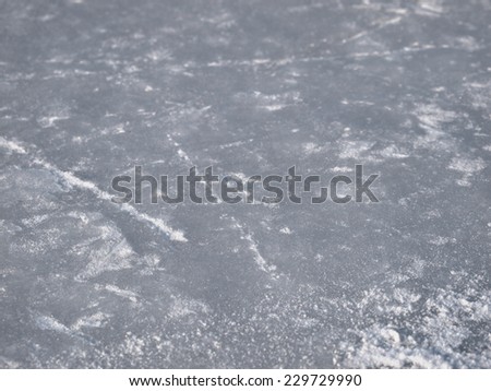 Ice rink surface background with selective focus,  hockey and figure skates tracks and scratches texture