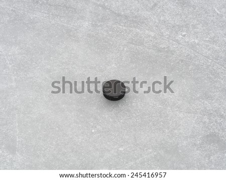 Puck on ice hockey rink surface, naturally frozen, winter sports background