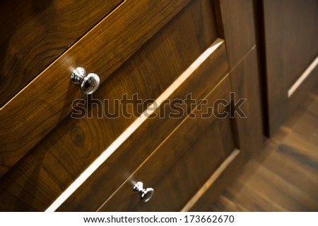 a wooden wardrobe drawer front, metal handle