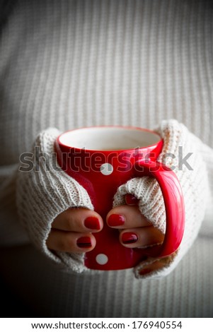 Female hands with coffee drink, knitted sweater