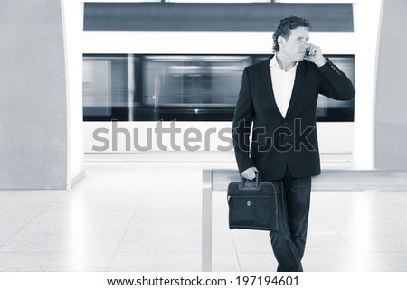 businessman with phone in the subway, blurred