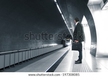man waiting in a subway station, blurred