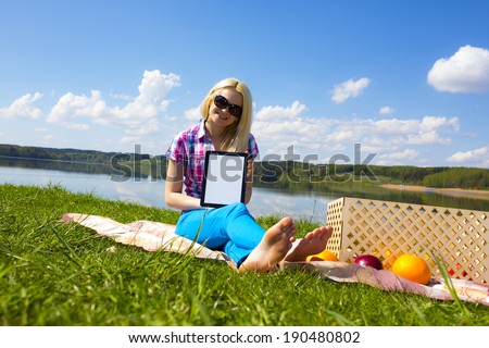 Woman holding tablet frame picnic