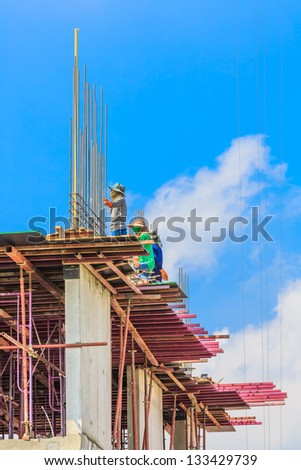 construction workers at the construction site with white cloud and blue sky