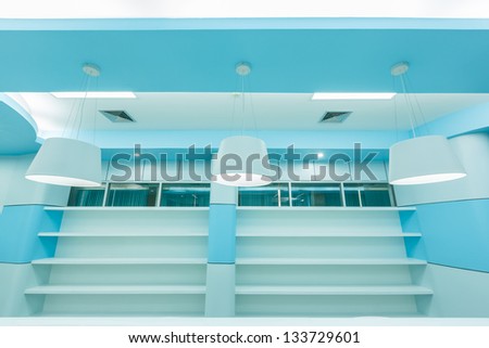 bookshelf and white ceiling lamp in empty modern library
