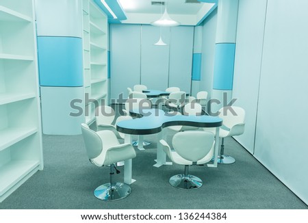 blue tables and white chairs in the empty modern library