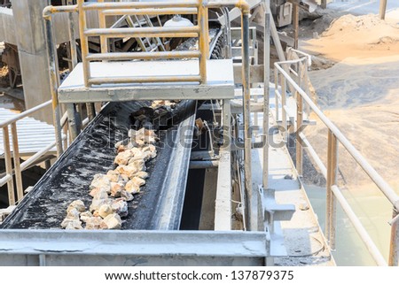 crushed rock passing conveyor belt at mining industry