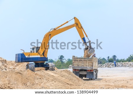 excavator loading sand on dumper truck at dolomite mines site