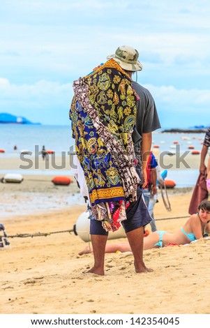 PATTAYA, THAILAND - MAY 25: Local merchant waiting for selling souvenirs to tourists at Pattaya beach on May 25, 13, it is a city in Thailand, a beach resort popular with tourists and expatriates