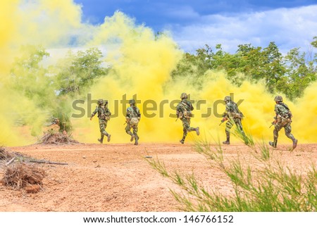 soldiers running behind yellow smoke screen