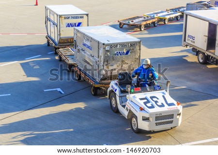 Tokyo - April 13: All Nippon Airways (Ana) Worker Pulling Container Pallets At Narita Airport On April 13, 2013, Ana Is One Of Largest Airlines Of Japan With 177 Passenger Planes